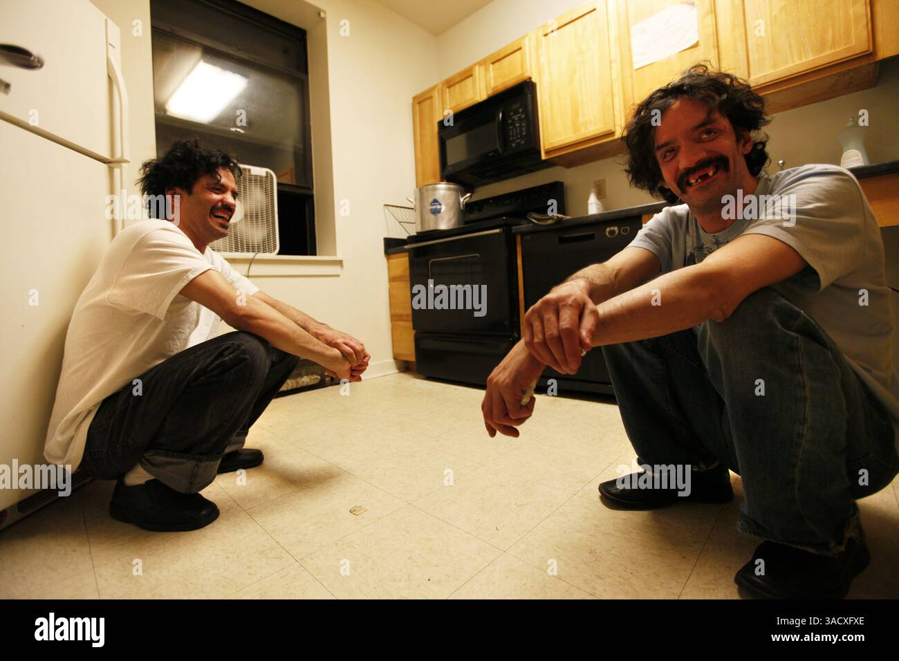 6. Januar 2012 – Chicago, IL, USA – die Zwillingsbrüder Frank, Left und Anthony Nowotnik teilen sich Witze, während sie am 6. Januar 2012 auf ihren Hühnereintopf in der Küche der Wohnanlage Uptown warten, in der sie heute in Chicago, Illinois, leben. (Bild: © Chris Walker/Chicago Tribune/MCT/ZUMAPRESS.com) Stockfoto