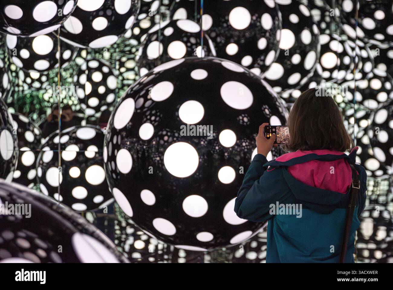 Porto, Portugal, eine Kunstinstallation, die einen Spiegelraum mit schwarzen Kugeln und weißen Punkten zeigt, die von der Decke hängen, Teil der Kunstserie Polka Dots von Yayoi Kusama, ausgestellt in der Serralves Foundation in Porto Stockfoto