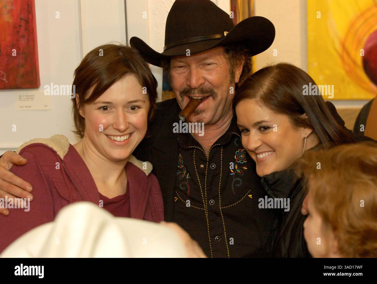 18. Februar 2006: Dallas, Texas, USA – Musiker, Bestseller-Autor und Möchtegern-Gouverneur Kinky Friedman posiert für ein Foto mit zwei seiner vielen Fans und Unterstützer, die sich in der Firehouse Art Gallery in Fort Worth, Texas, TX, versammelten. Am Montag, den 20. Februar 2006, um ihre Plakate, T-Shirts und andere Erinnerungsstücke von dem Mann signieren zu lassen, der liebevoll als Kinkster bekannt ist. Friedmans Stumpfrede musste trotz des ungewöhnlich kalten Wetters ins Freie verschoben werden, um die überströmte Menge aufzunehmen, die in Friedmans Ausführungen im Stil von will Rogers über den düsteren Zustand der texanischen Politik schwelgte. Sein Stockfoto