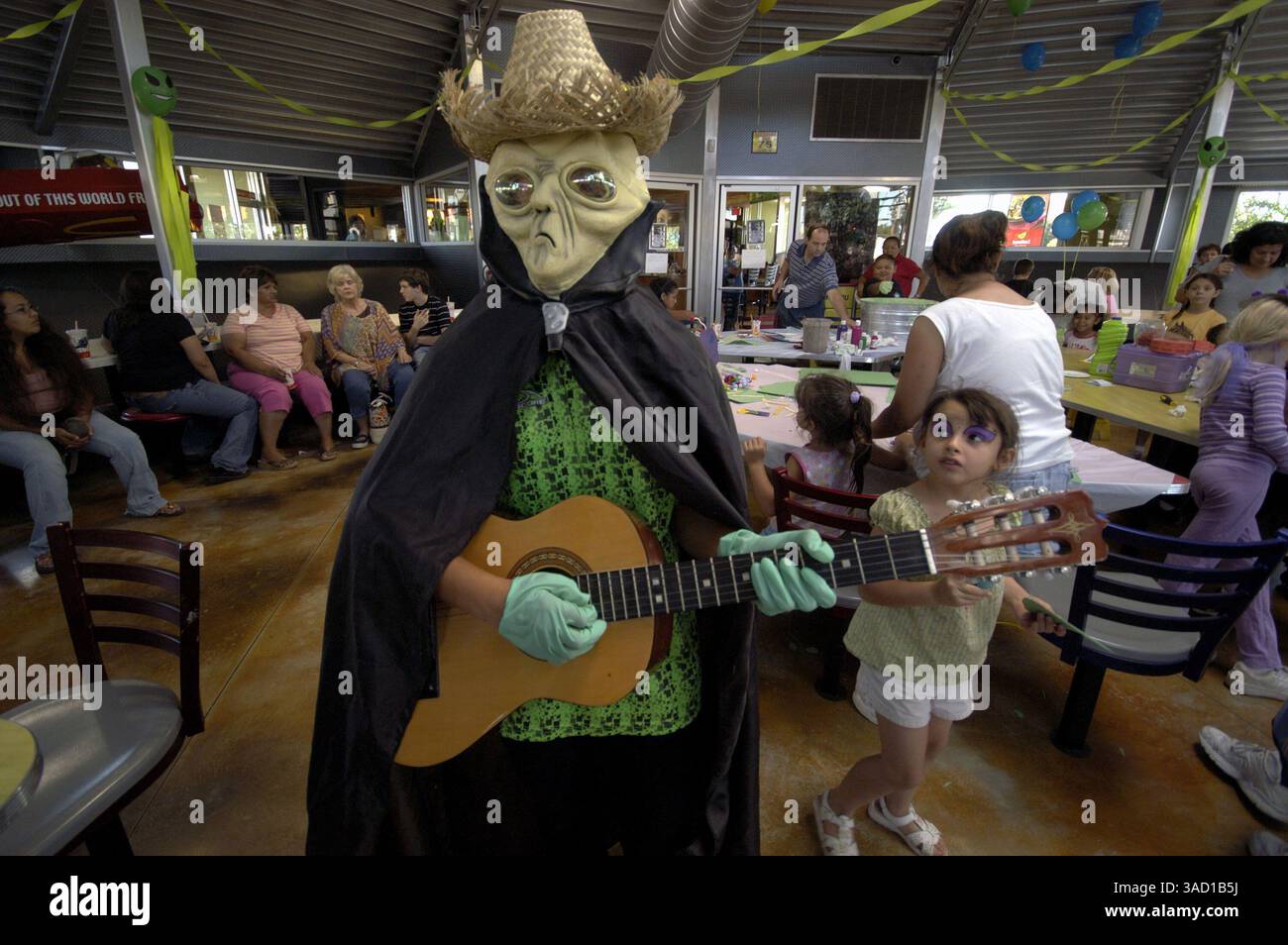 Juli 2007 - Roswell, New Mexico, USA - Alien-Gitarristin Jennifer Gerstner, 11 Jahre alt, stimmt vor dem Start des Kinderkostümwettbewerbs am Donnerstag, den 5. Juli 2007 in Roswell, New Mexcio, im McDonald's Restaurant ein. .2007 jährt sich zum 60. Jahrestag des Roswell-Vorfalls, der angeblichen Entdeckung einer abgestürzten fliegenden Untertasse 30 Meilen nördlich der Innenstadt von Roswell durch den Rancher W. „Mac“ Brazel und der mutmaßlichen „Vertuschung“ durch das US-Militär, die die Überreste an der Absturzstelle offiziell als „einen streng geheimen Wetterballon“ bezeichnete. Das Roswell-Festival, mit einer ganzen Reihe von Elementen, die attraktiv sind Stockfoto