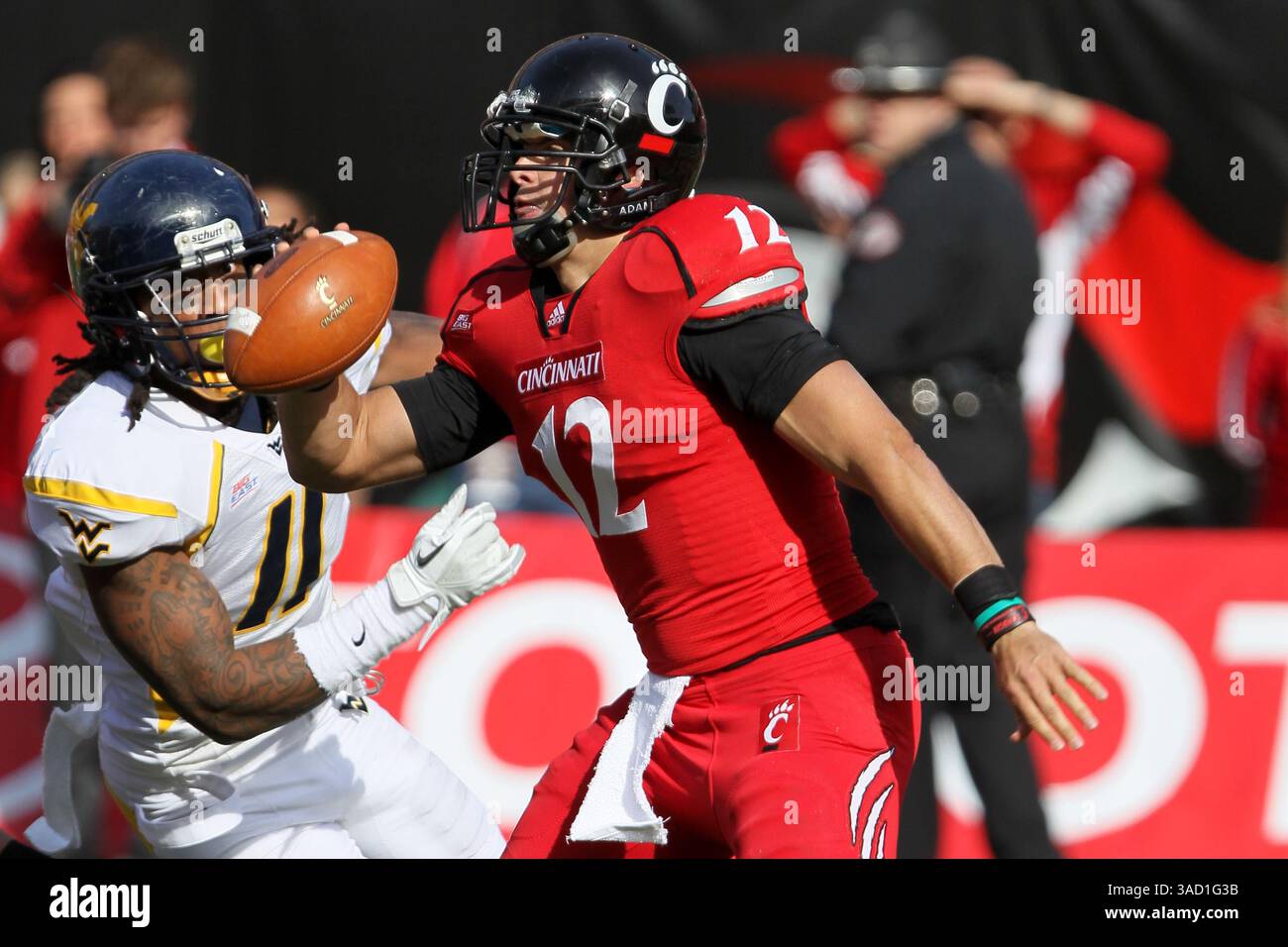 November 2011 - Cincinnati, Ohio, USA S - Cincinnati Bearcats Quarterback Zach Collaros (12) wird von West Virginia Mountaineers Defensive End Bruce Irvin (11) im NCAA-Football-Spiel zwischen den West Virginia Mountaineers und den Cincinnati Bearcats in Cincinnati, OH, verfolgt. West Virginia führt die Bearcats 17-7 in der Halbzeit an. (Bild: © Jon Longo/Southcreek/ZUMAPRESS.com) Stockfoto