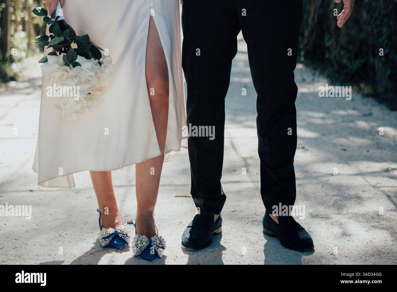 Brautpaar, Detail, Beine mit Hochzeitskleid und dunkelblauen Schuhen, Mann im Anzug Stockfoto