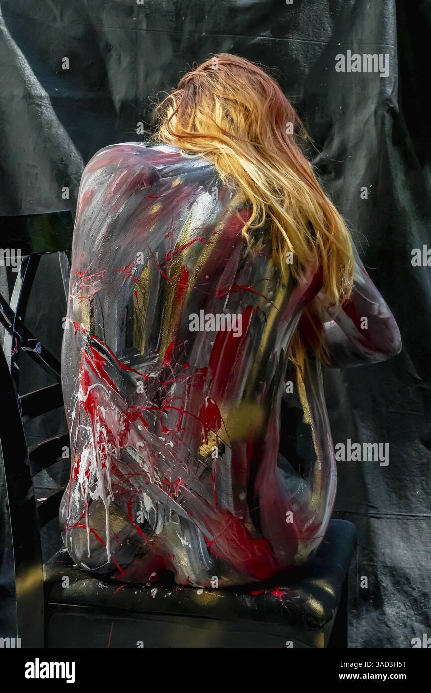 Ein Model posiert anmutig, ihr Körper ist mit lebendiger Körperfarbe verziert, mit brillanten, schwungvollen Strichen, die ihre Form in eine lebendige Leinwand verwandeln. Alle Stockfoto