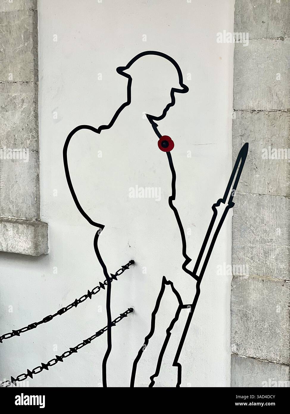 Minimalistisch schwarze Silhouette eines Soldaten aus dem Ersten Weltkrieg mit Gewehr und rotem Mohn zur Erinnerung. Stacheldrahtelemente symbolisieren Opfer. - Smartphone-aufgenommenes Stockfoto