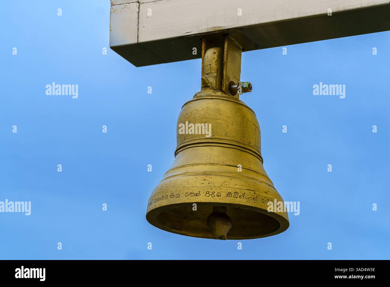 Eine goldene Tempelglocke im Nelligala International Buddhist Centre, Sri Lanka, verziert mit heiligen Inschriften, die spirituelles Erwachen und Devo symbolisieren Stockfoto