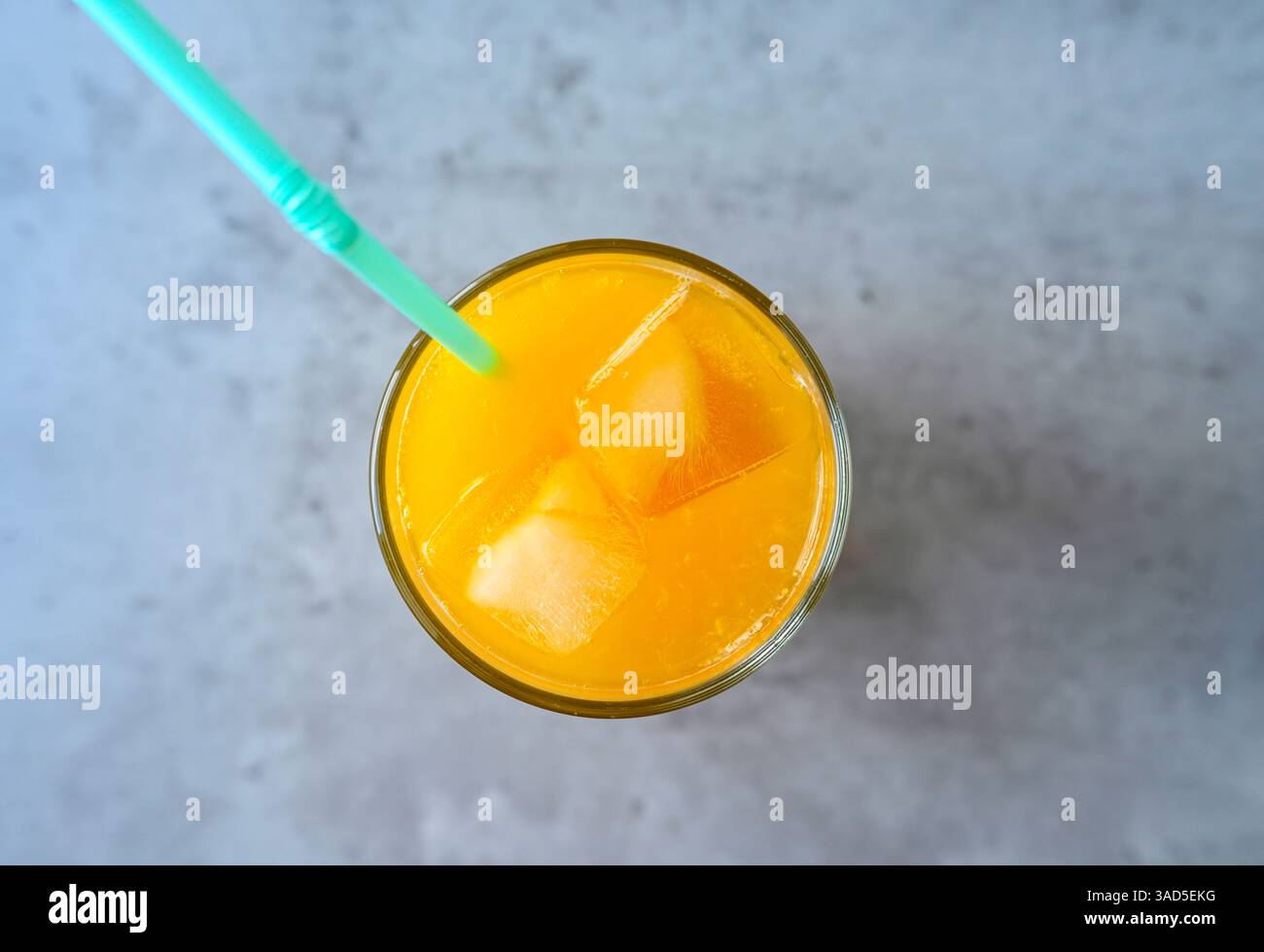 Glas frischer Orangensaft mit Strohhalm und Eis Stockfoto