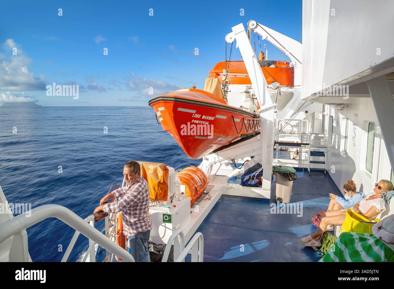 PORTO SANTO, PORTUGAL - 26. AUGUST 2021: Nicht identifizierte Passagiere genießen eine Seereise auf dem Deck einer Seefähre. Stockfoto PORTO SANTO, PORTUGAL - 26. AUGUST 2021: Nicht identifizierte Passagiere genießen eine Seereise auf dem Deck einer Seefähre. Stockfoto