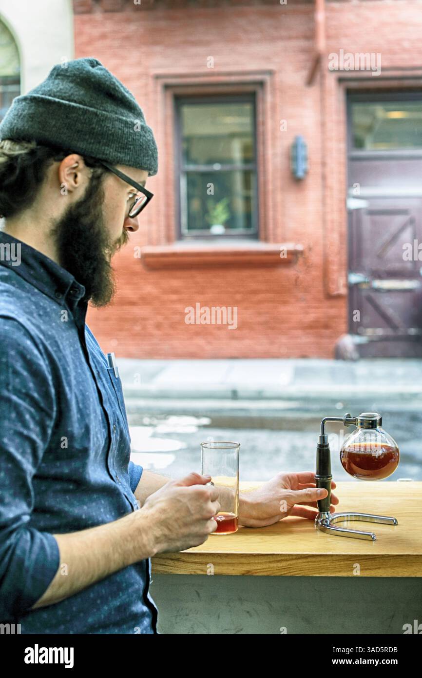 Der Barista bereitet Kaffee im Siphon zu Stockfoto