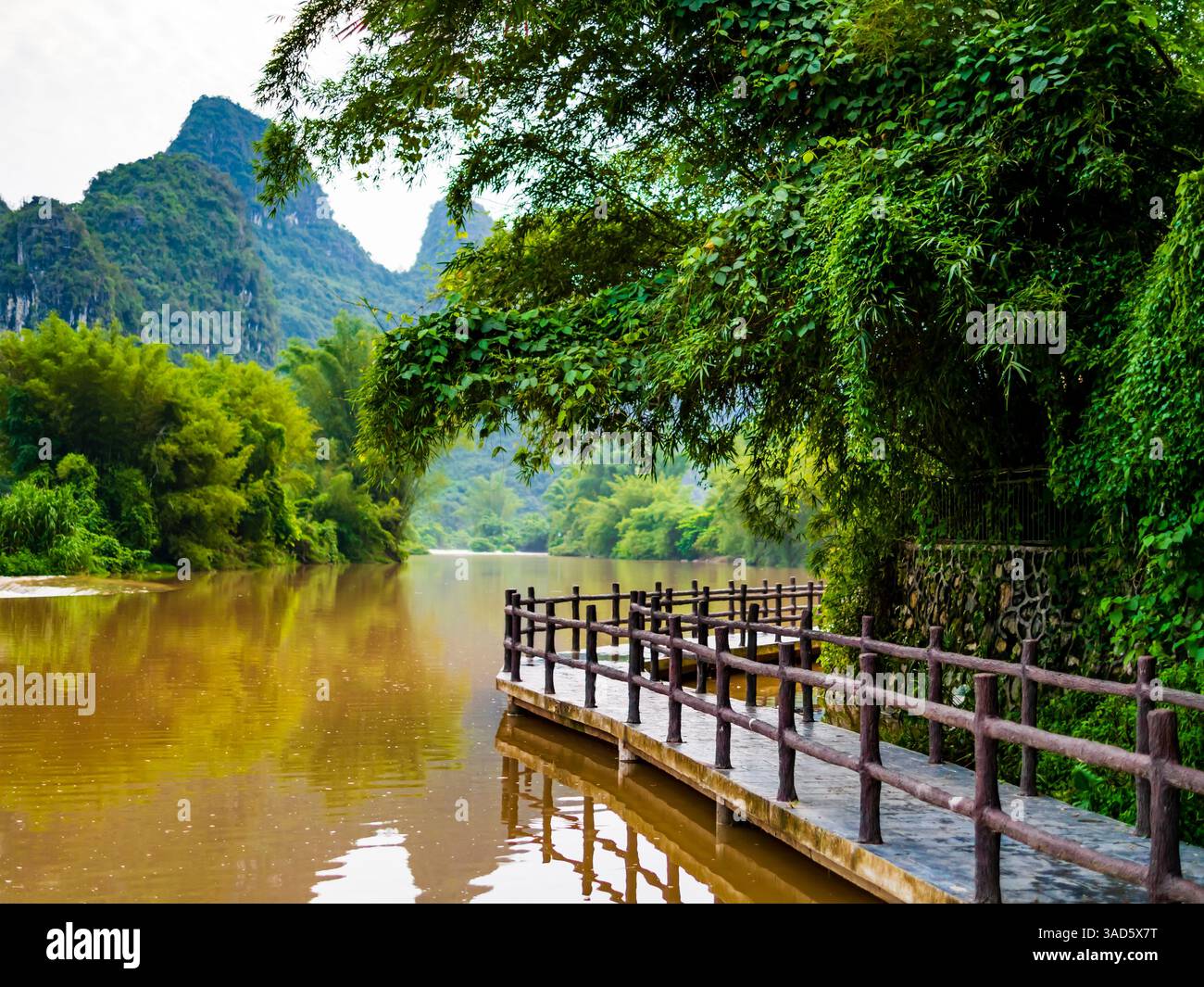 Atemberaubende Landschaft von Yangshuo mit Karstbergen und Holzbrücke, die am Ufer des Flusses Li, Guangxi, China verläuft Stockfoto