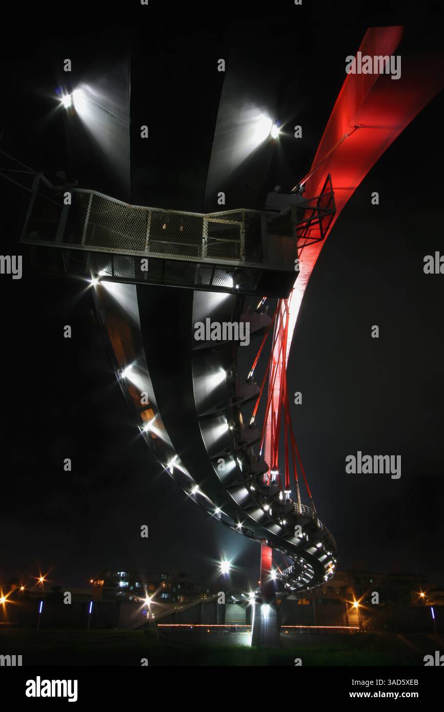 Ein atemberaubender Blick auf die Regenbogenbrücke in Taipeh, Taiwan, bei Nacht beleuchtet und über den Keelung River. Stockfoto