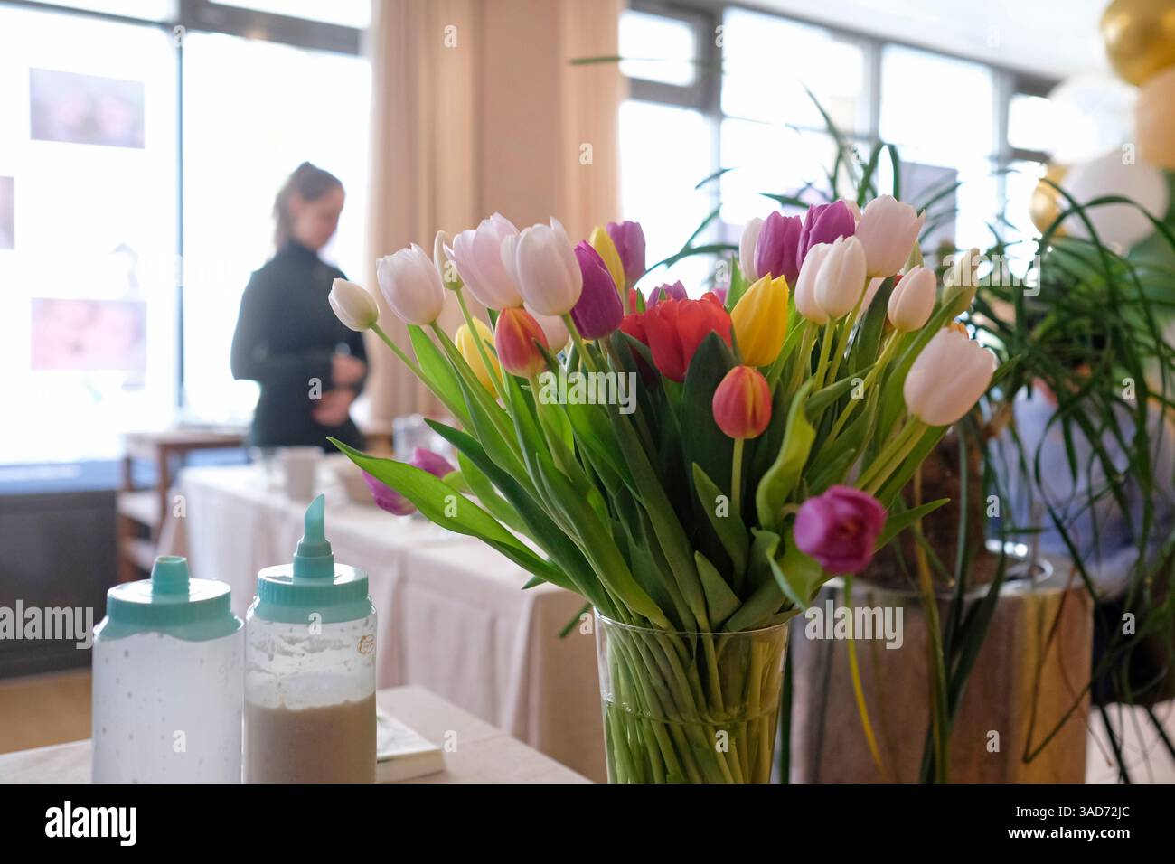 Bunte Tulpen in einer Vase an einem Büroempfang Stockfoto