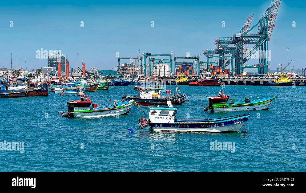 Geschäftiger Hafen mit Fischerbooten und Industriekränen Stockfoto