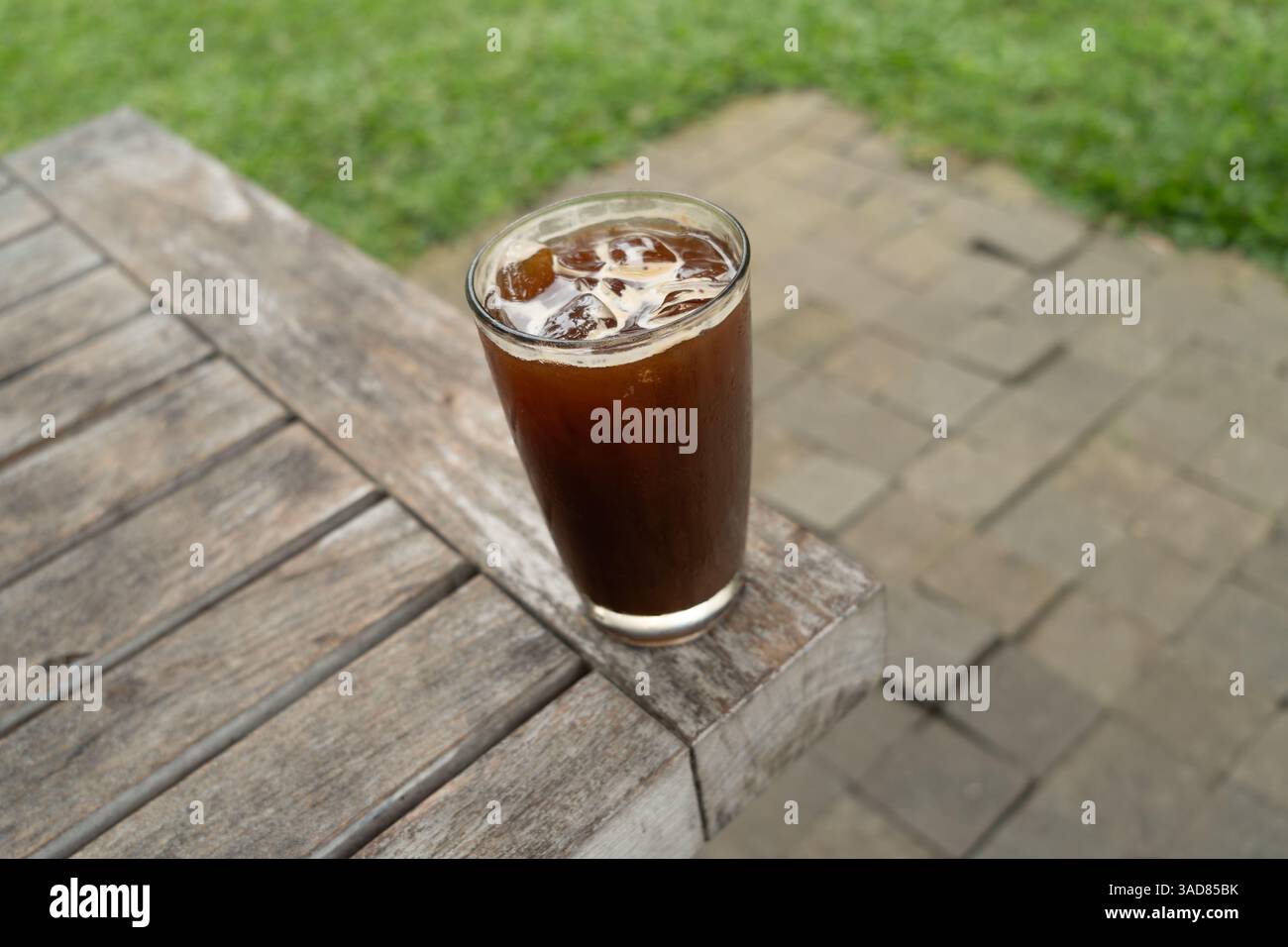 Eiskaffee in einem hohen Glas über dem Tisch. Kaltes Sommergetränk Stockfoto