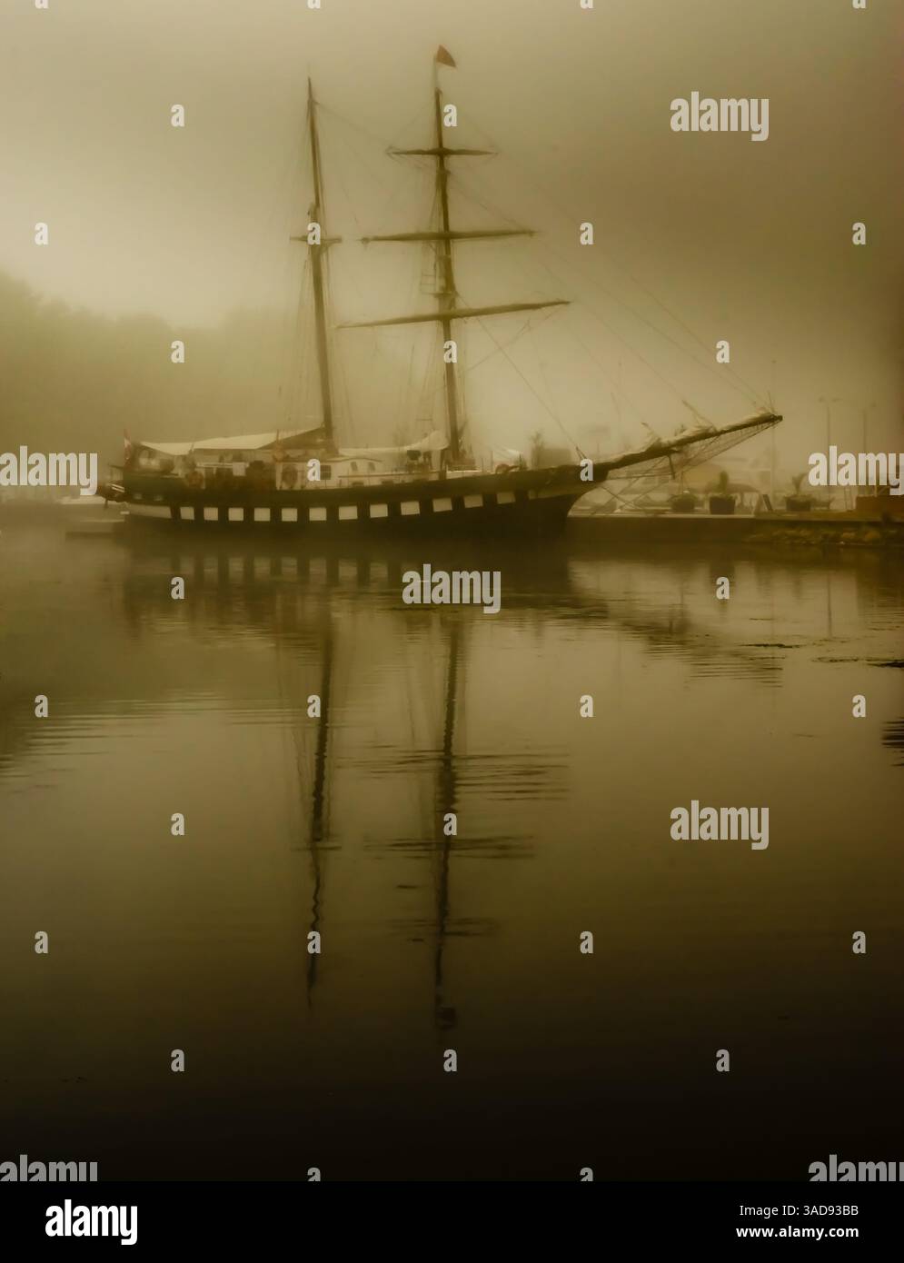 Sepia getönte Aussicht auf ein großes Schiff, das im Morgennebel an einem Pier am St. Lawrence River ankert Stockfoto