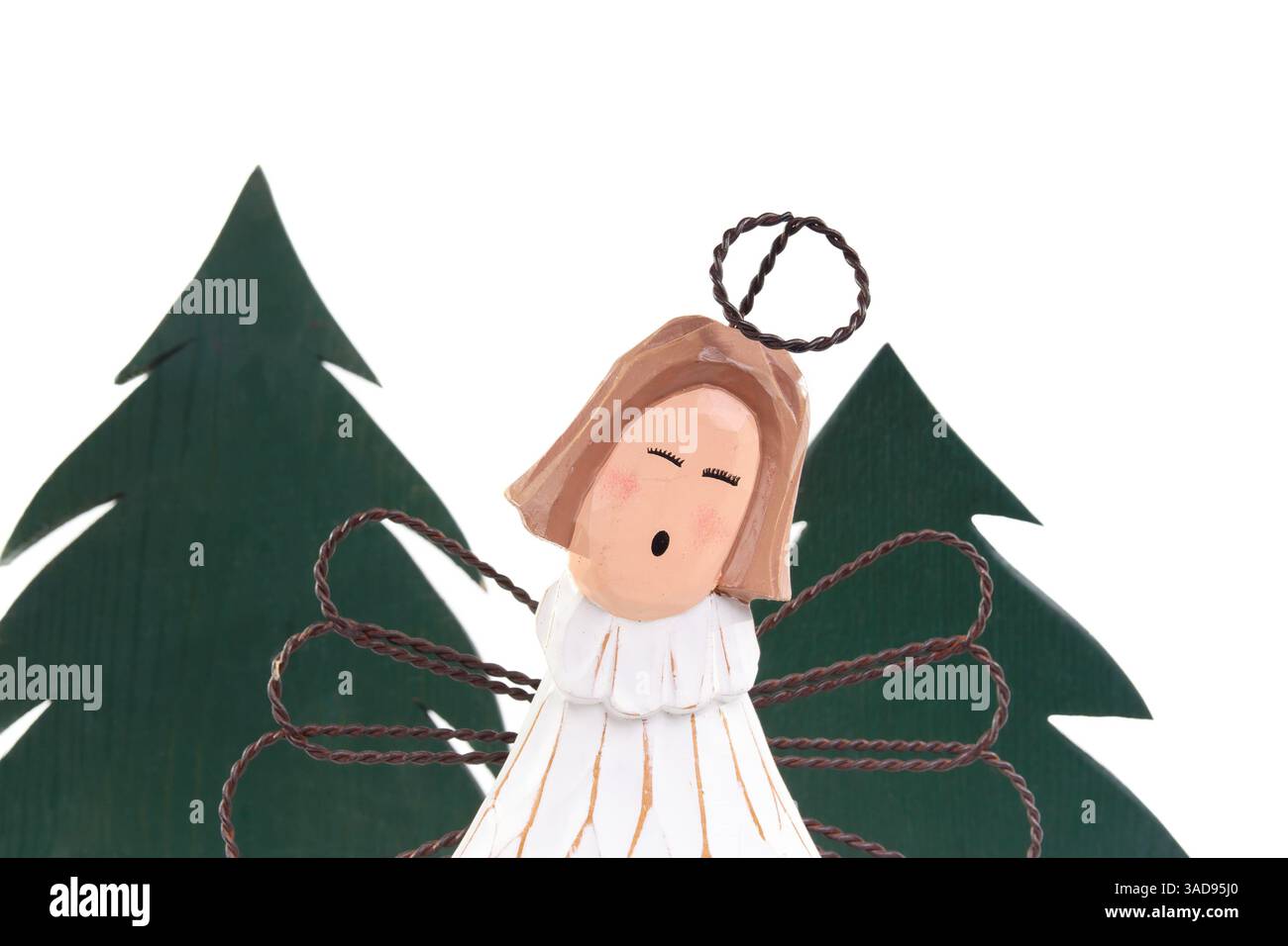 Isolierter Holzengel vor Weihnachtsbäumen. Hölzerner Weihnachtsbaum mit süßem Weihnachtswächter. Minimalistisches Design. Weihnachtsdekoration oder Celebr Stockfoto