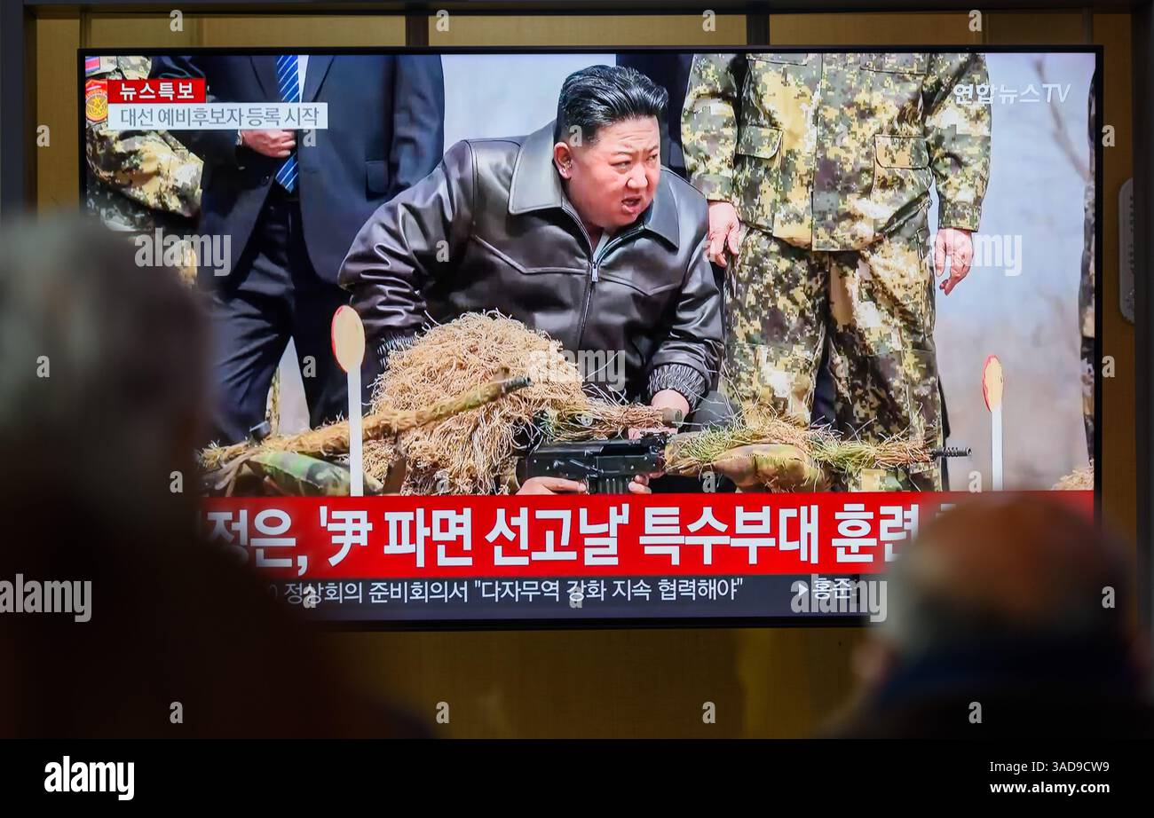 Die Leute sehen sich eine 24-stündige Yonhap-Nachrichtensendung am Bahnhof Seoul an, die eine Nachrichtensendung mit dem nordkoreanischen Führer Kim Jong UN zeigt, der eine Trainingsbasis der Spezialeinsatzkräfte der koreanischen Volksarmee besucht, um eine umfassende Trainingseinheit an einem nicht offengelegten Ort in Nordkorea zu beobachten. Der nordkoreanische Führer Kim Jong UN inspizierte Anfang dieser Woche die Ausbildungsaktivitäten von Spezialeinheiten und betonte, dass die Stärkung ihrer Fähigkeiten der Schlüssel zum Aufbau einer starken Armee sei, berichteten die staatlichen Medien Nordkoreas am 5. April. Stockfoto