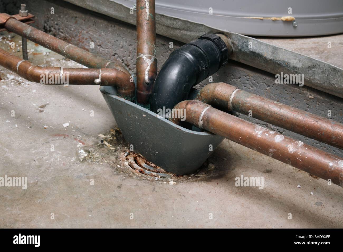 Bodenabfluss des Kesselraums oder Bodenreinigungsabfluss Nahaufnahme. Abflusssystem zum Schutz vor Überschwemmungen und zur einfachen Wartung. Kupferrohre von Warmwassertanks Stockfoto