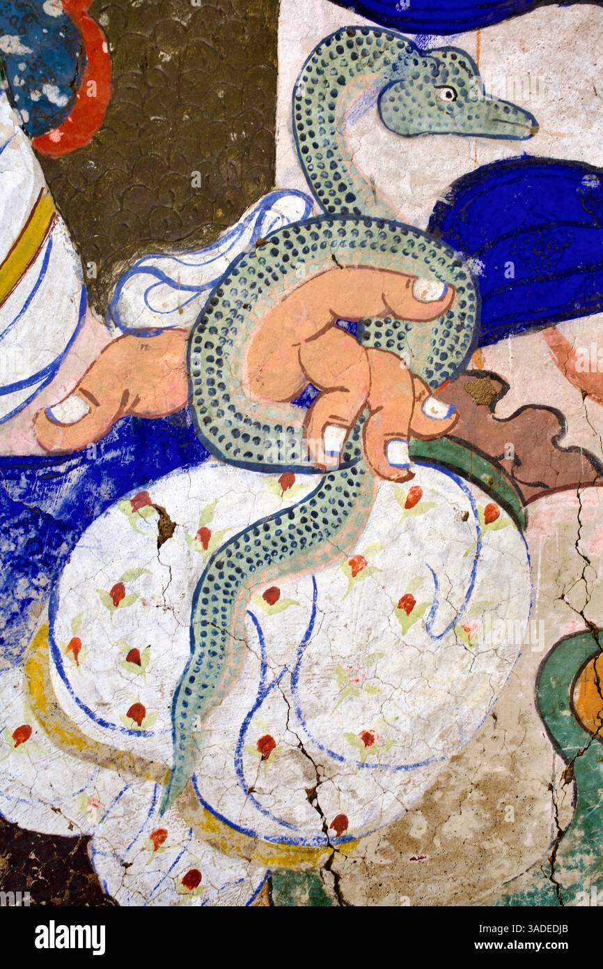 Die Hand der Gottheit greift eine grüne Schlange in symbolischer Geste aus dem Wandgemälde im Thiksey Kloster in Ladakh. Stockfoto