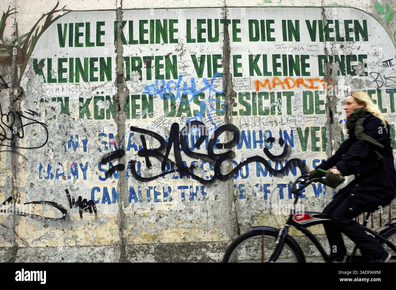 East, Side, Gallery, 2008, Berlin, Deutschland, Europa, Wandkunst mit Zitat und Frau auf dem Fahrrad, umgeben von Graffiti, Europa Stockfoto