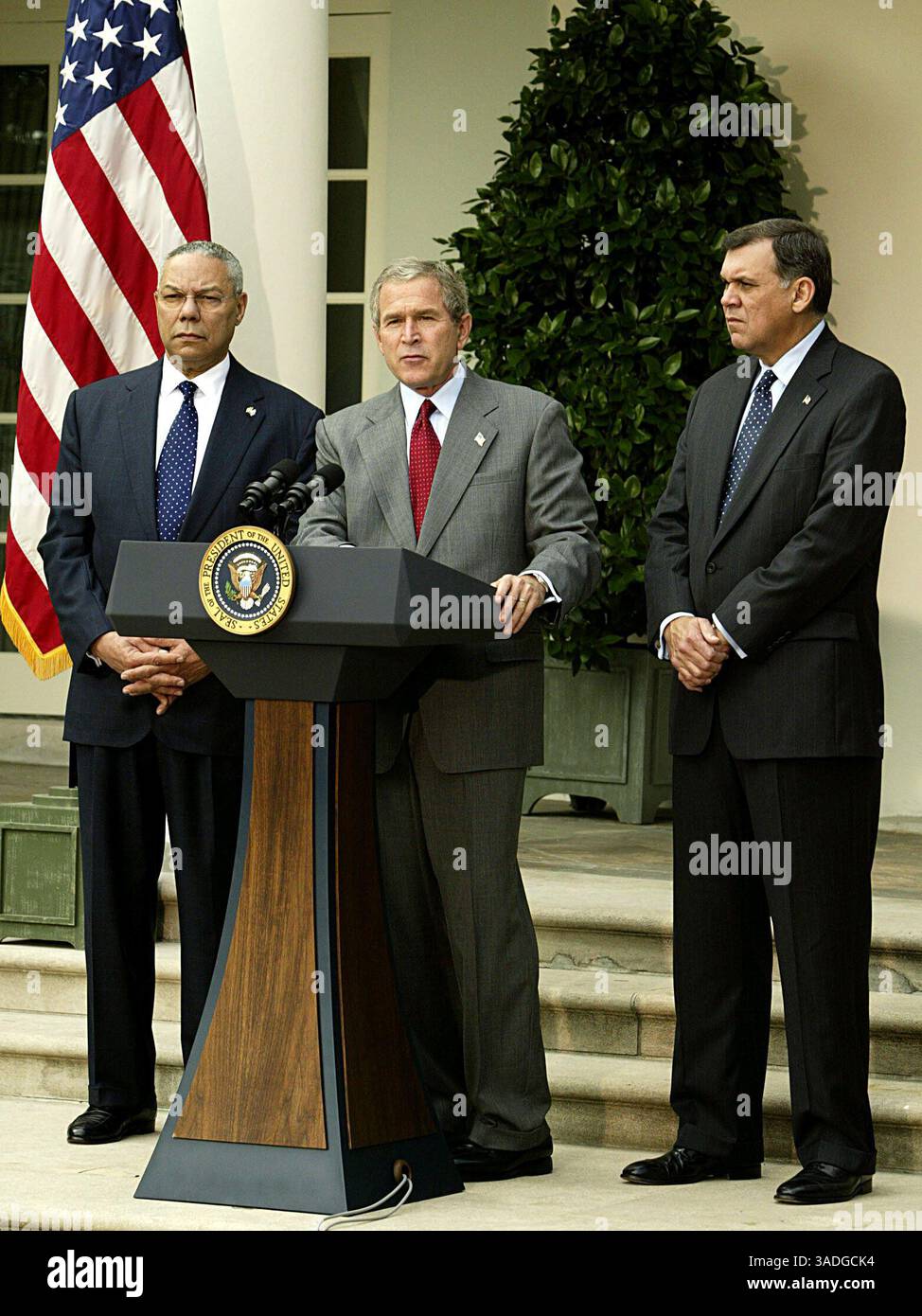 Oktober 2003; Washington, DC, USA; US-Präsident GEORGE W. BUSH gibt eine Erklärung über Kuba im Rosengarten des Weißen Hauses ab. Mit Bush sind Außenminister COLIN POWELL (L) und Minister für Gesundheit und Stadtentwicklung MEL MARTINEZ (R). Bush sprach neben anderen Fragen im Zusammenhang mit Kuba auch von der Notwendigkeit, die in Kuba ausgegebenen Fremdwährungen einzuschränken. (Bild: Chris Kleponis/ZUMAPRESS.com) Stockfoto