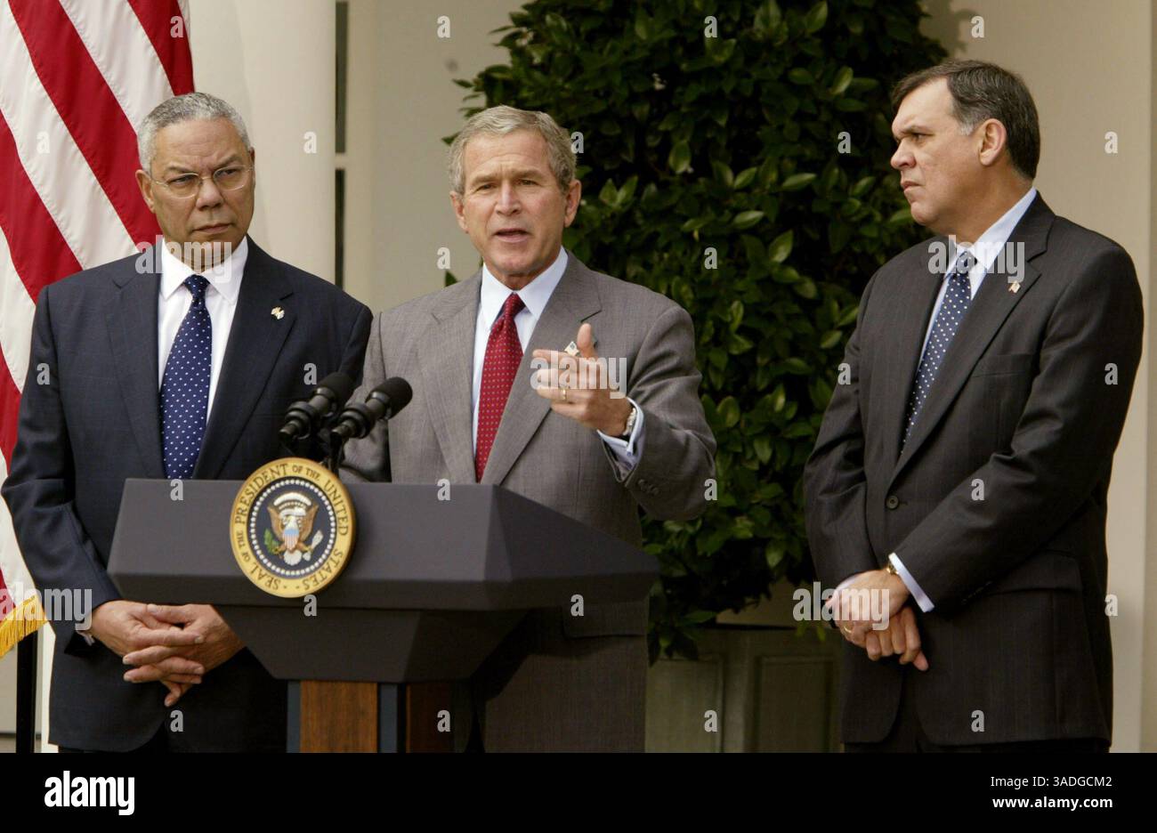 Oktober 2003; Washington, DC, USA; US-Präsident GEORGE W. BUSH gibt eine Erklärung über Kuba im Rosengarten des Weißen Hauses ab. Mit Bush sind Außenminister COLIN POWELL (L) und Minister für Gesundheit und Stadtentwicklung MEL MARTINEZ (R). Bush sprach neben anderen Fragen im Zusammenhang mit Kuba auch von der Notwendigkeit, die in Kuba ausgegebenen Fremdwährungen einzuschränken. (Bild: Chris Kleponis/ZUMAPRESS.com) Stockfoto