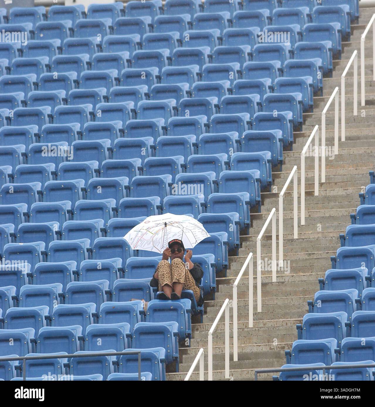 Ein großer Fan wartet darauf, dass der Regen aufhört und während eines Spiels bei den US Open in Flushing Meadows, NY, am Donnerstag, den 4. September 2003, weiterspielt. Der Regen hörte schließlich auf und die Spiele wurden am Nachmittag fortgesetzt. (Bild: Jeff Klein/ZUMAPRESS.com) Stockfoto
