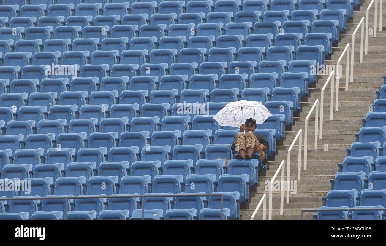 Ein großer Fan wartet darauf, dass der Regen aufhört und während eines Spiels bei den US Open in Flushing Meadows, NY, am Donnerstag, den 4. September 2003, weiterspielt. Der Regen hörte schließlich auf und die Spiele wurden am Nachmittag fortgesetzt. (Bild: Jeff Klein/ZUMAPRESS.com) Stockfoto