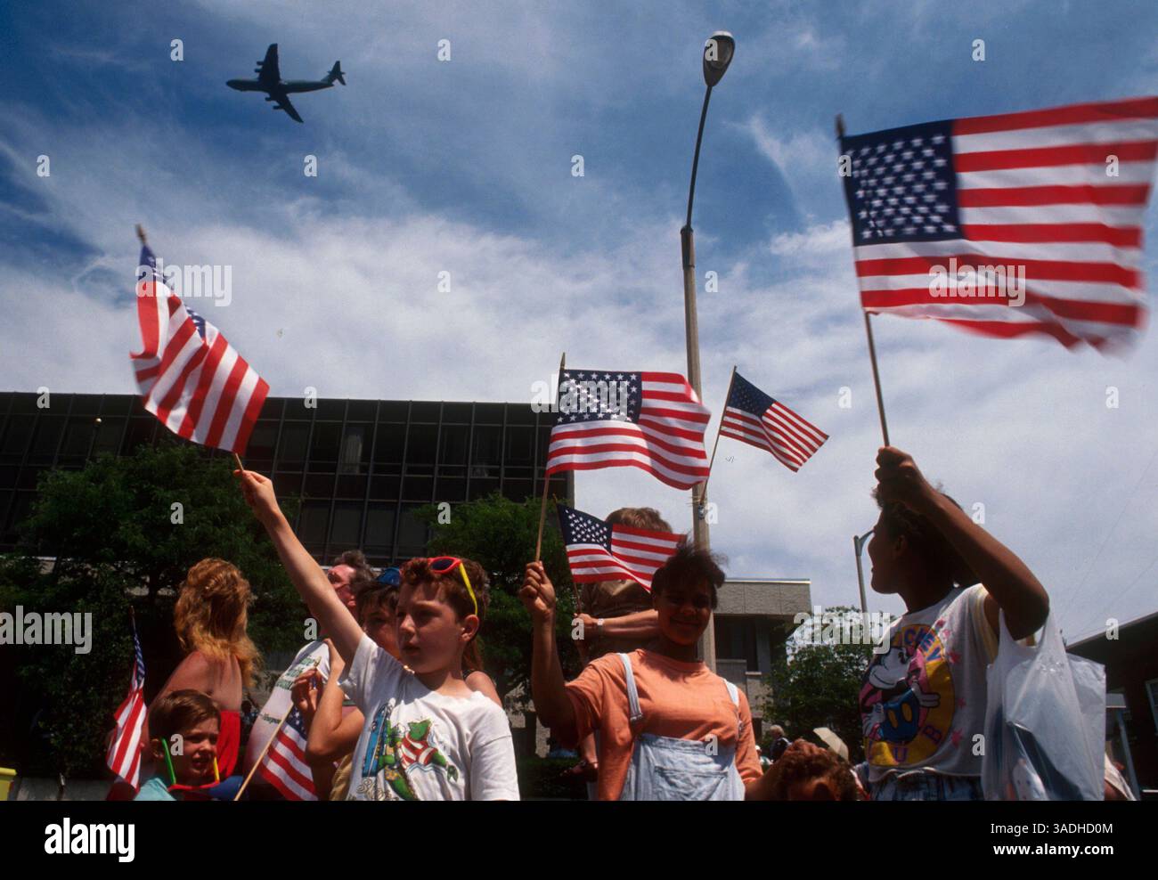 Juni 1991; Newburgh, NY, USA; die Zuschauer beobachten, wie eine Air Force C5 Galaxy bei der Military Appreciation Parade die Sterne und Streifen der amerikanischen Flagge in Newburgh, NY, über den Himmel fliegt. Die Parade fand statt, nachdem US-Truppen nach dem Golfkrieg gegen den Irak nach Hause kamen. . (Bild: Jack Kurtz/ZUMAPRESS.com) Stockfoto