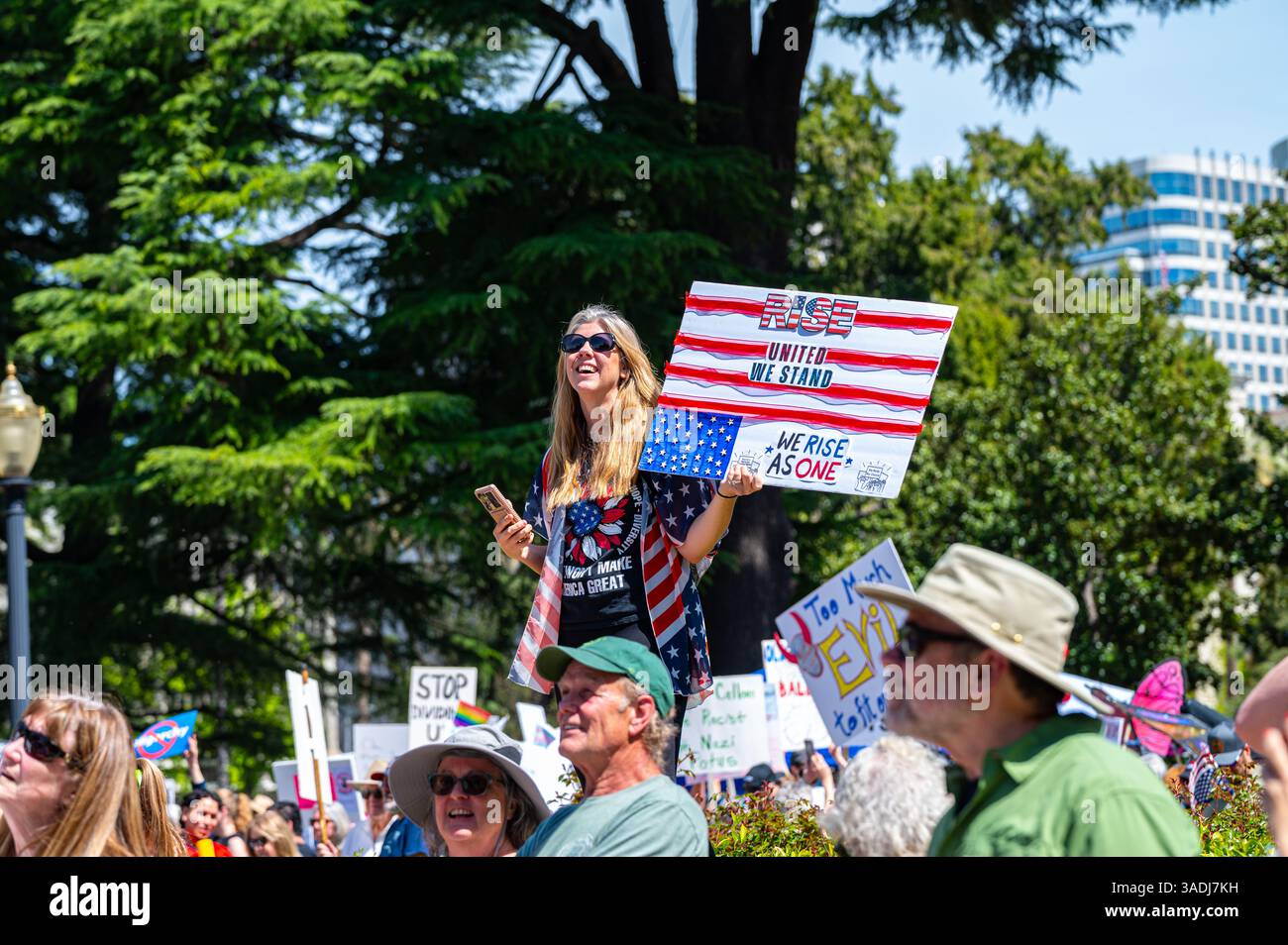 Eine Frau hält ein Flaggenschild über den Aufstand und die vereinigung vor dem Kapitolgebäude bei der Demonstration der Hände-weg-Demonstration, die in der Innenstadt im Kapitol stattfand. Stockfoto
