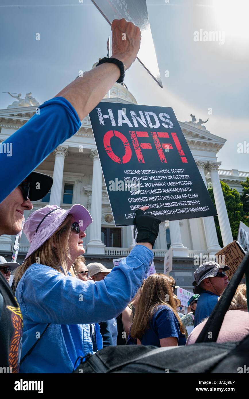 Eine Frau hält ein detailliertes Hands-Off-Schild mit vor dem Kapitolgebäude bei der 50501 Hands-Off-Proteste, die in der Innenstadt auf dem Kapitolgelände stattfanden. Stockfoto