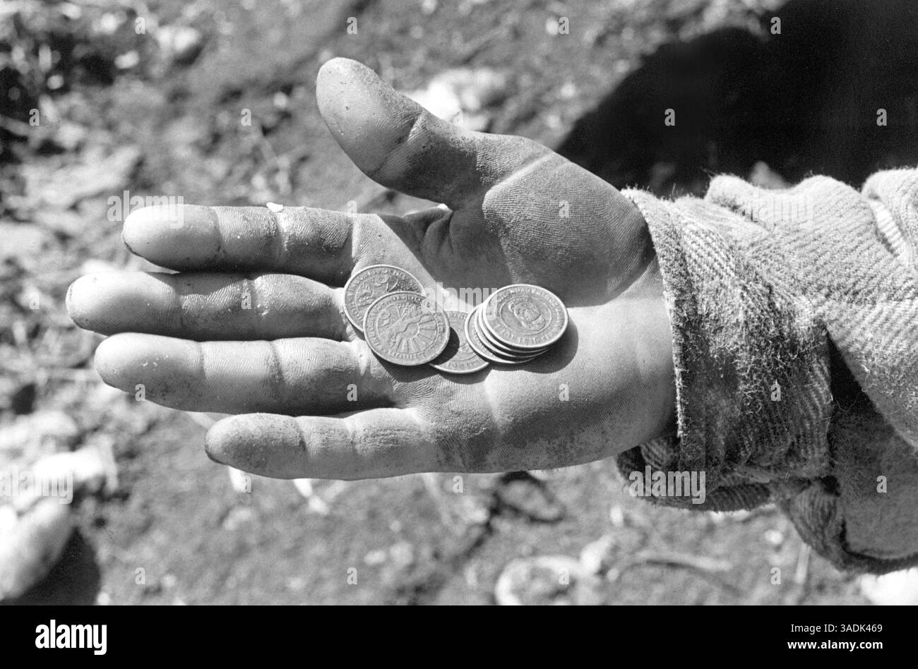 Dezember 2004; Stockton, CA, USA; Tomatenarbeiter erhalten für jedes Paar Eimer, das sie füllen, ein Zeichen, das insgesamt etwa 30 Pfund beträgt. Der Wert der Token schwankt mit dem Marktpreis der Tomaten. An diesem Tag waren die Token $0,95 Wert. Dieser Mann hält seinen Lohn für die Arbeit eines morgens. Das Migrantenprojekt hat sich zum Ziel gesetzt, eines zu tun: Den Menschen ein menschliches Gesicht zu geben, ob es sich um Familien handelt, die monatelang in der Traubensaison im Dreck von Mekka leben, Tomatenpflücker in Stockton, die durch schlammige Felder gleiten und 30-Pfund-Eimer in glühender Hitze schleppen, Stockfoto