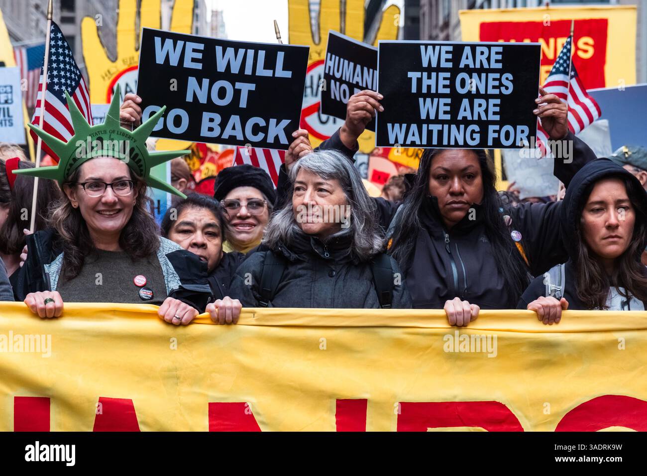 Demonstrantinnen mit einem Banner und einem Plakat, auf dem während der Demonstration steht: „Wir werden nicht zurückgehen“ und „Wir sind diejenigen, auf die wir warten“. Trotz des Regens versammeln sich Tausende von Demonstranten im Bryant Park und marschieren im Rahmen einer landesweiten Anti-Trump-Kundgebung zum Madison Square Park. Mehr als 1200 Städte und Städte sind beteiligt, aber auch einige im Ausland. Der Protest wurde von einer Koalition mehrerer Interessengruppen organisiert, darunter The Invisible, MoveOn, 50501 Movement & Women's March. Die Demonstranten fordern „Hands Off“ Gesundheitsfürsorge, soziale Sicherheit, Bildung und protestieren gegen die iss Stockfoto Demonstrantinnen mit einem Banner und einem Plakat, auf dem während der Demonstration steht: „Wir werden nicht zurückgehen“ und „Wir sind diejenigen, auf die wir warten“. Trotz des Regens versammeln sich Tausende von Demonstranten im Bryant Park und marschieren im Rahmen einer landesweiten Anti-Trump-Kundgebung zum Madison Square Park. Mehr als 1200 Städte und Städte sind beteiligt, aber auch einige im Ausland. Der Protest wurde von einer Koalition mehrerer Interessengruppen organisiert, darunter The Invisible, MoveOn, 50501 Movement & Women's March. Die Demonstranten fordern „Hands Off“ Gesundheitsfürsorge, soziale Sicherheit, Bildung und protestieren gegen die iss Stockfoto
