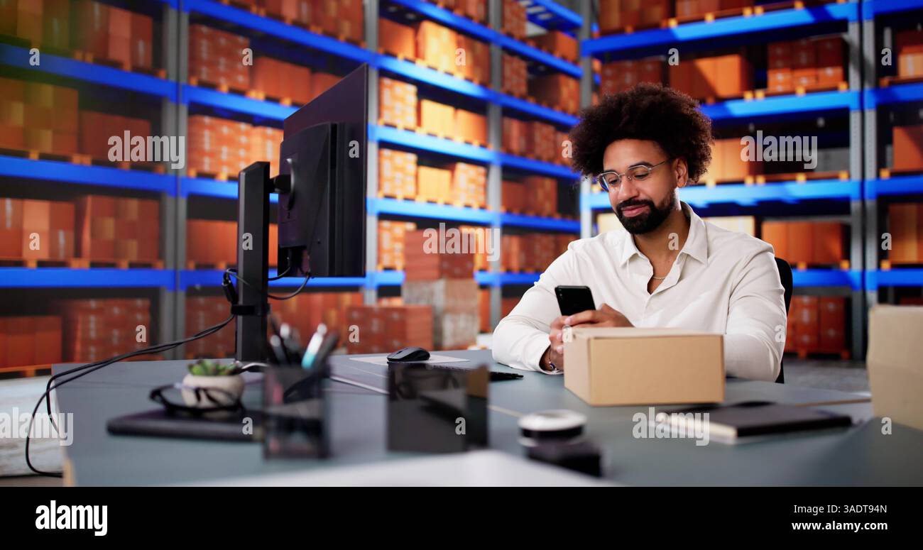 Afroamerikaner scannt Barcodes mit Smartphone in kleinem Bürolager. Stockfoto