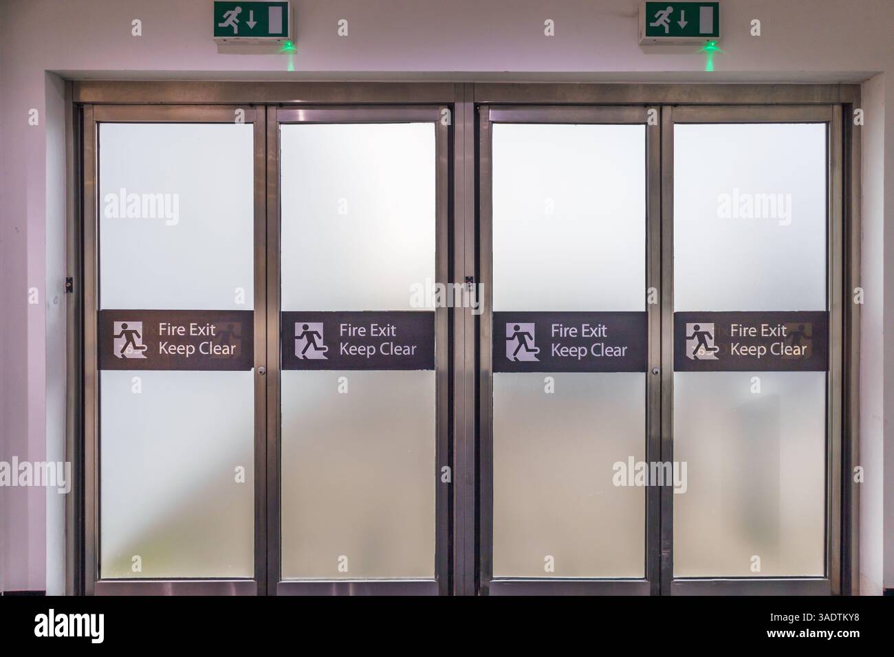 Ausstiegstüren mit Schiebeleiste mit Notsignatur im öffentlichen Gebäude Stockfoto