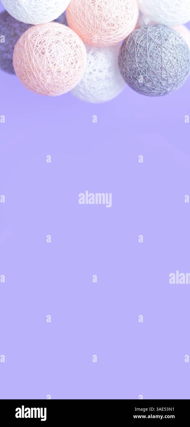 Niedliche Grußkarte mit pastellfarbenen Garnkugeln auf lila Hintergrund. Hintergrund für Telefone und Grußansagen Stockfoto