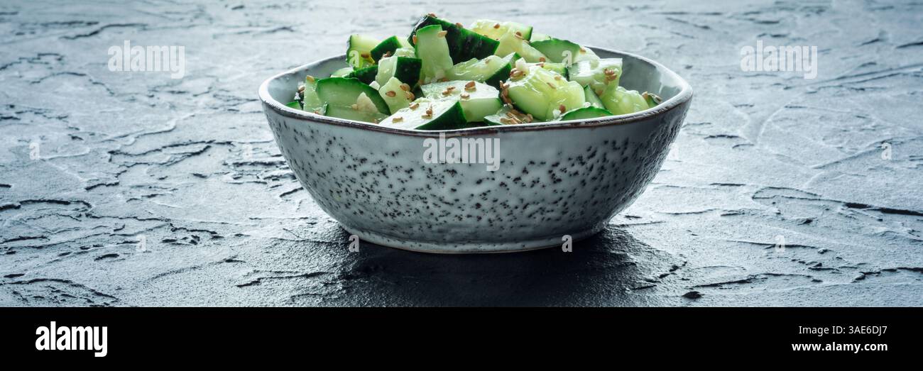 Zerschmetterte Gurkensalat Panorama, gesundes veganes Essen, grüner Snack, auf schwarzem Hintergrund gedreht Stockfoto
