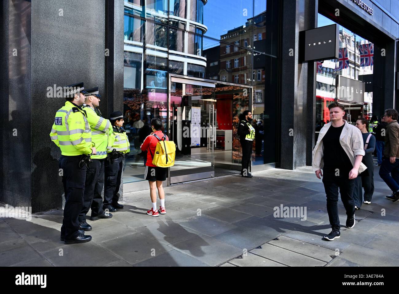 Polizeibeamte bewachen den Tesla Showroom während eines Tesla Takedown Protestes in der Oxford Street, London, Großbritannien Stockfoto
