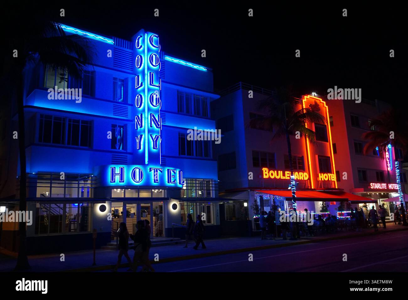 Blaue Neonlichter vom Colony Hotel erhellen die Straße am South Beach, Miami Beach Boardwalk bei Nacht. Stockfoto