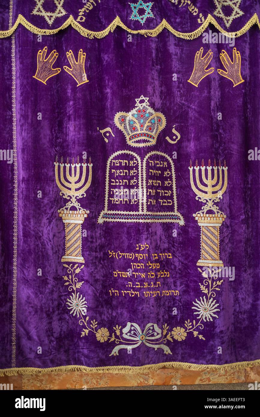 Haifa, Israel, 5. April 2025, Innenansicht einer Aram-Zzova-Synagoge. Detaillierte Nahaufnahme eines reich gestickten lila Parochet (Torah Arche Vorhang) Stockfoto