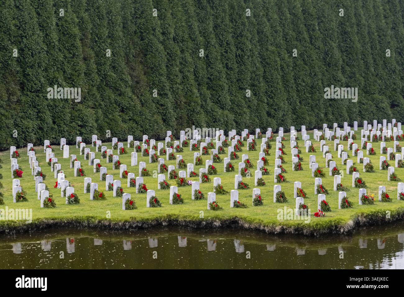 Auf einem Hügel erinnert ein Veteranenfriedhof mit weißen Grabsteinen und der amerikanischen Flagge an tiefe Ehre, Opfer und dauerhaften Nationalstolz, Salisbury, UN Stockfoto