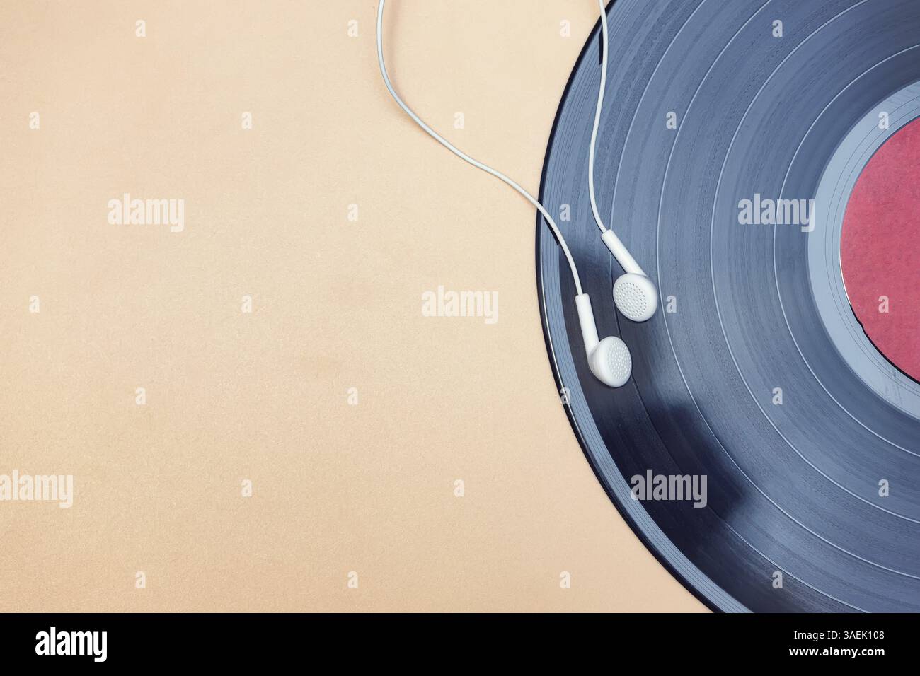 Moderne, kleine Kopfhörer und eine klassische Schallplatte aus Vinyl Stockfoto