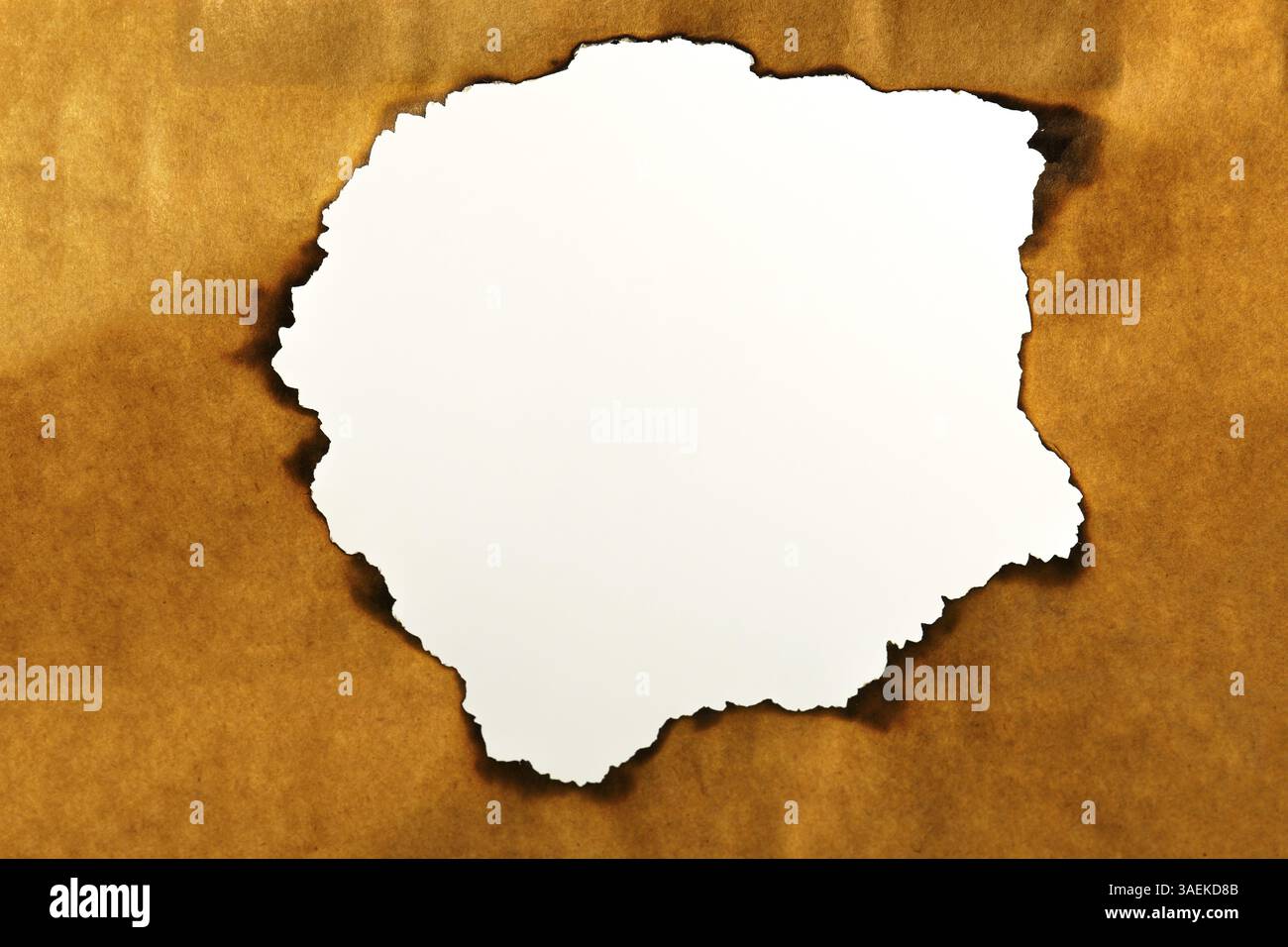 Gebranntes braunes Papier mit weißem Loch in der Mitte für Text Stockfoto