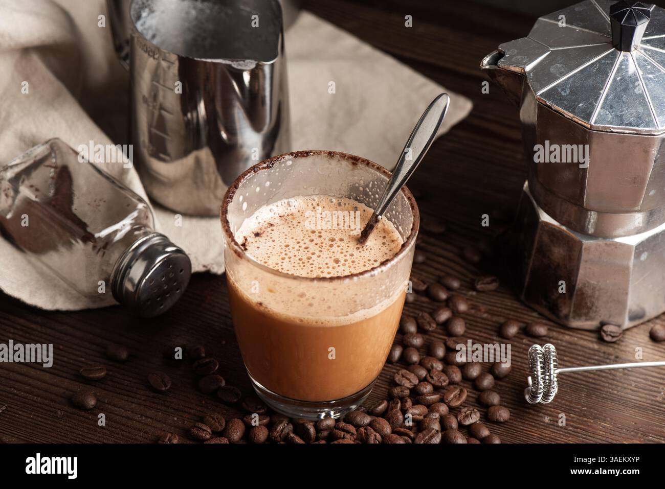 Ich trinke heißen Thai Tee Latte. Heißgetränk mit Kaffeebohnen und Mokakanne. Stockfoto