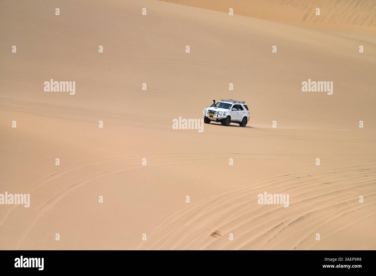 Ein 4x4-Fahrzeug, das durch die riesigen Sanddünen im Namib-Naukluft-Nationalpark in der Nähe von Sandwich Harbour, Namibia, navigiert. Diese aufregende Öko-Abenteuer-Show Stockfoto