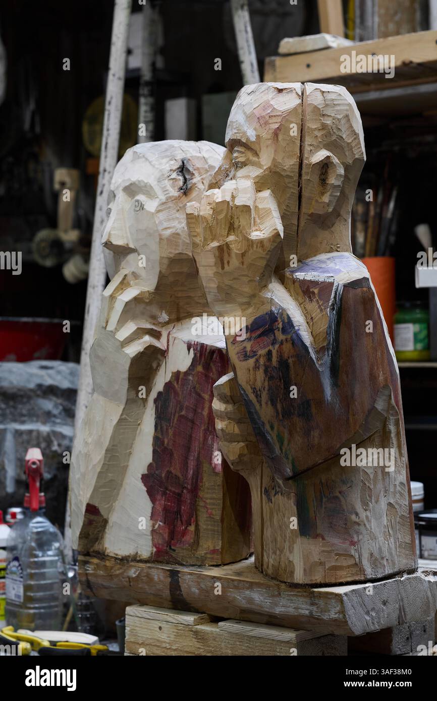 Eine wunderschön gefertigte Holzskulptur zeigt zwei künstlerische Figuren in einer kreativen Werkstatt Stockfoto