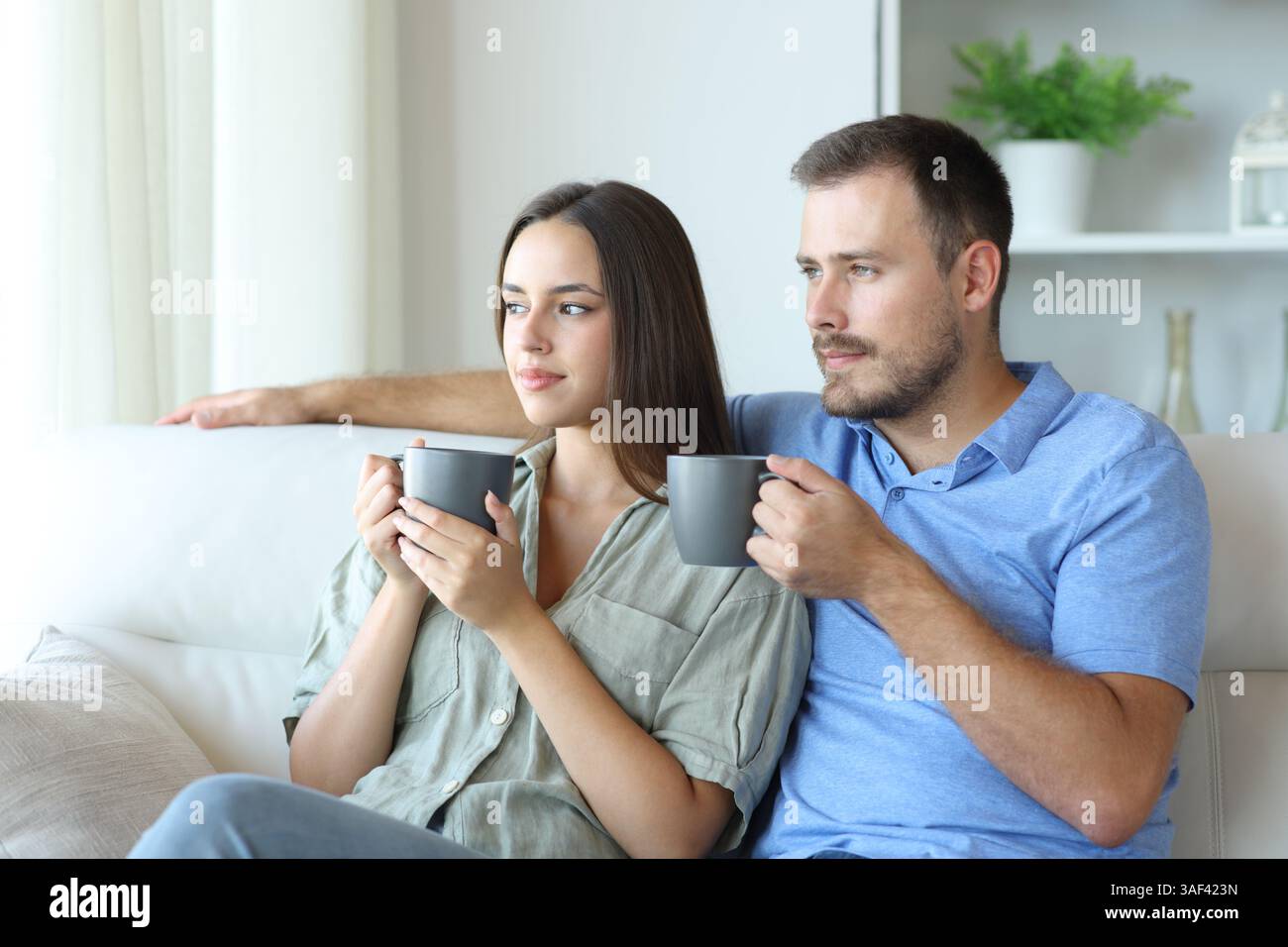 Entspanntes Paar trinkt Tee und entspannt auf einer Couch zu Hause Stockfoto