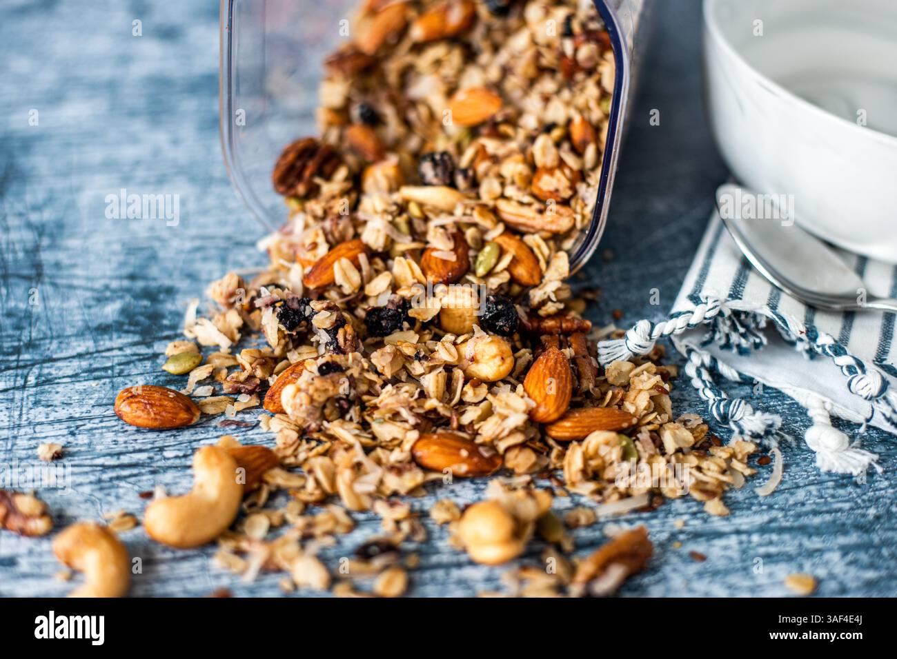 Granola verschüttet aus dem Behälter auf die Theke Stockfoto