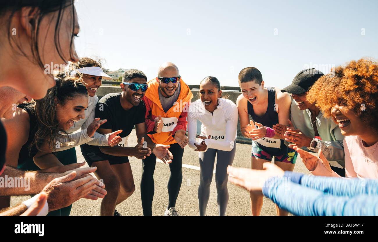 Eine lebendige Szene mit Freunden, die sich bei einem Marathon versammelten, sich gegenseitig hochjagen und mit Begeisterung klatschen. Themen der Freundschaft und Teamarbeit. Stockfoto