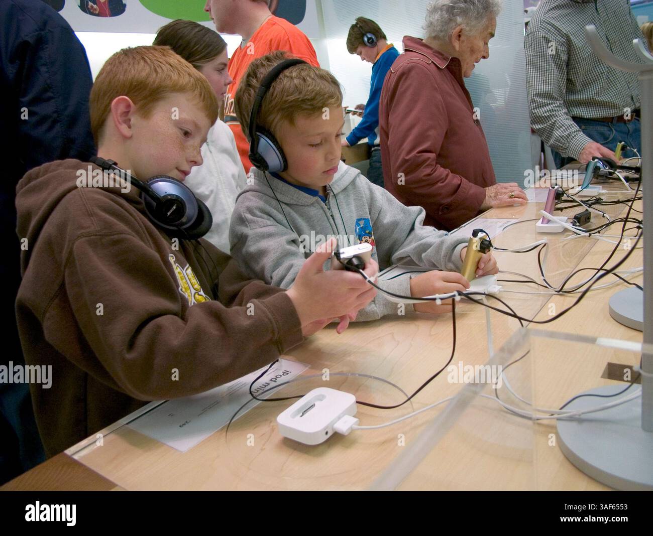 Februar 2005; Mission Viejo, CA, USA; Apple Computer, Inc. ist ein Silicon Valley-Unternehmen mit Sitz in Cupertino, Kalifornien, dessen Kerngeschäft Computertechnologien ist. Apple half mit dem Apple II in den 1970er Jahren, die PC-Revolution zu starten und formte es in den 1980er Jahren und seitdem mit dem Macintosh. Apple ist bekannt für innovative Software und Hardware, wie den iMac, den digitalen iPod-Musik-Player und den iTunes Music Store. Unternehmensziel von Apple: Die Leistungsfähigkeit der Computertechnik für jedermann verfügbar und zugänglich zu machen. Im Bild: Apple Store in der Mission Viejo Mall, wo Kinder und Menschen leben Stockfoto