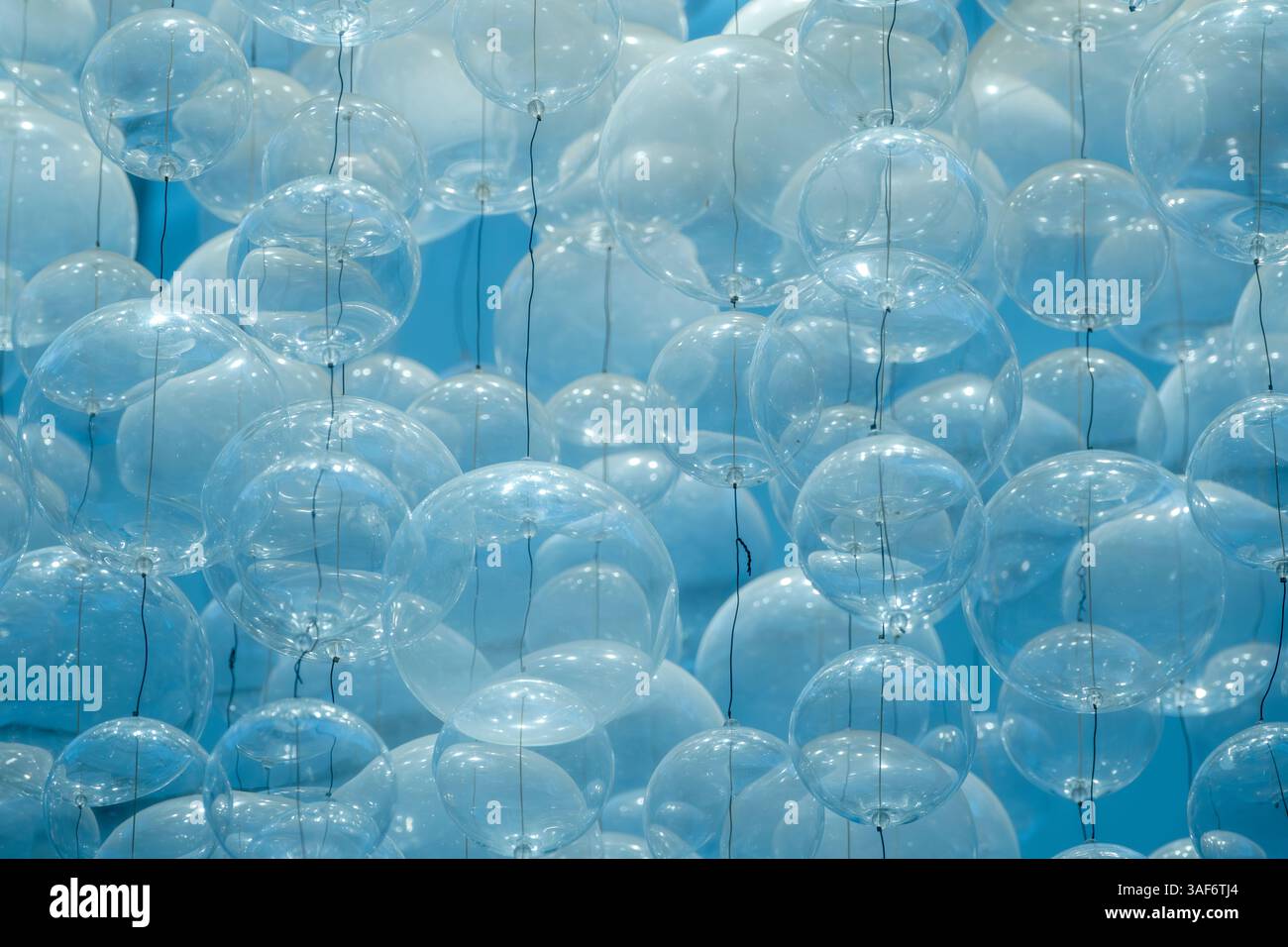 Blassblauer Hintergrund durch transparente, glänzende Kunststoffballons, die fest zusammengefügt sind Stockfoto